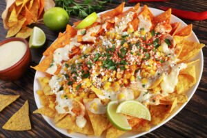 Plate with corn chips and cheese, corn, and spices on top 